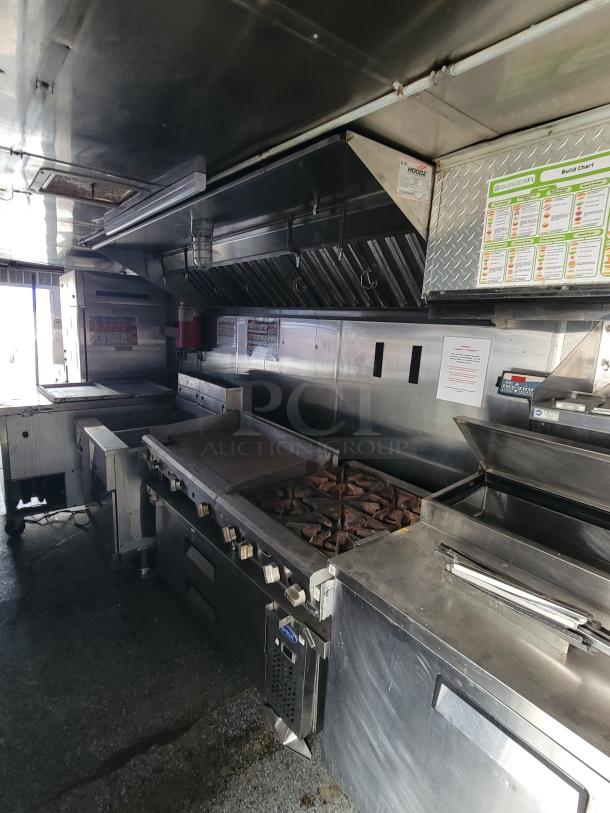 Quality Cargo Model 24 mobile kitchen with grill, burners, and prep area. Includes build charts; well-maintained stainless steel.
