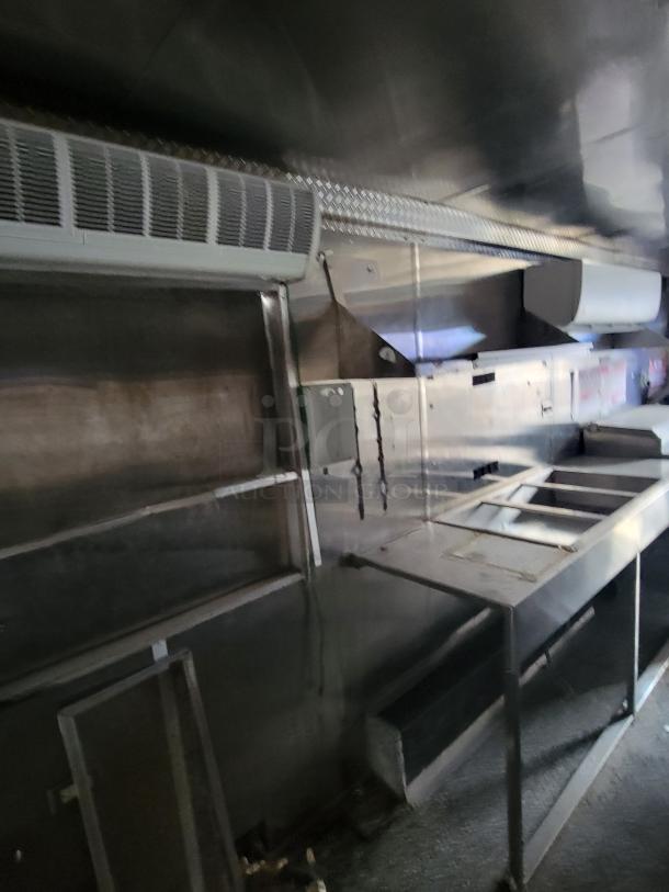 Quality Cargo Model 24 interior with stainless steel fixtures, ventilation system, and counters. Condition appears used.