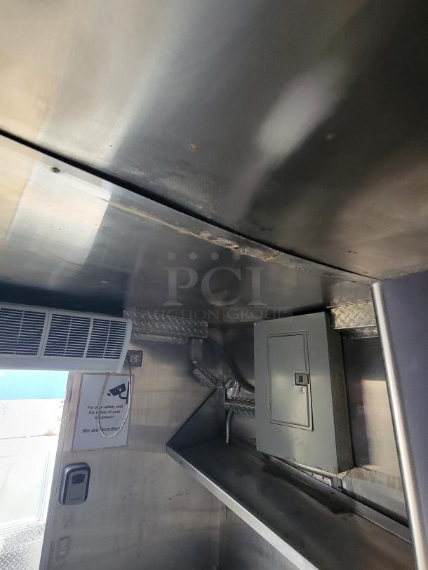 Quality Cargo Model 24 interior, featuring stainless steel shelves, an electrical panel, and ventilation. Clean, well-maintained condition.