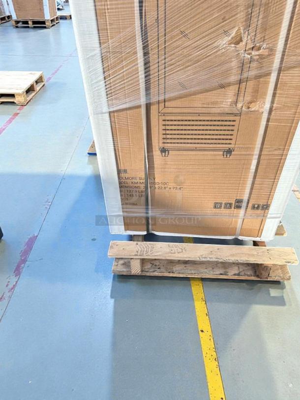 Brand new KoolMore glass door display refrigerator model MDR1GD12C, boxed on a pallet, minor dents on packaging.