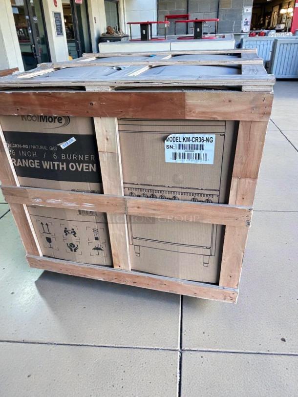 Brand new KoolMore 36" Gas Range in crate, model KM-CRG36-NG. Visible labels indicate natural gas use, scratch & dent condition.