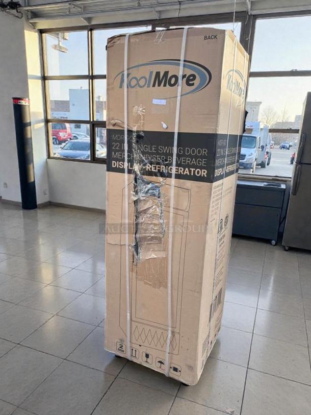 Brand new KoolMore MDR-9CP electric merchandiser refrigerator, 9 cu. ft., in shipping box, shows scratch and dent damage.