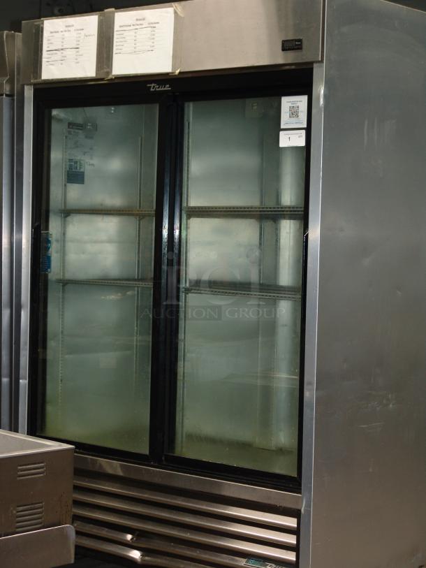 True 1/10" reach-in refrigerator with two sliding glass doors, 115v, stainless steel exterior, visible interior shelves, used condition.
