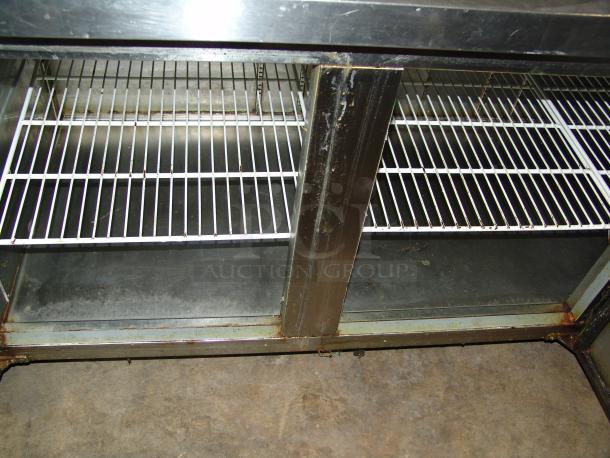 Kelvinator KCPT92.12 pizza prep table, 24 cu. ft., stainless steel finish, dual shelving, visible wear and rust along edges.