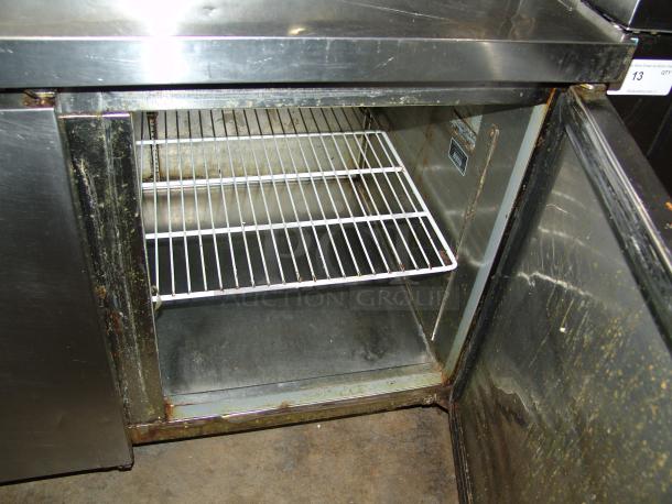 Kelvinator KCPT92.12 24 cu. ft. pizza prep table in used condition, showing an open interior with wire shelf and visible wear.