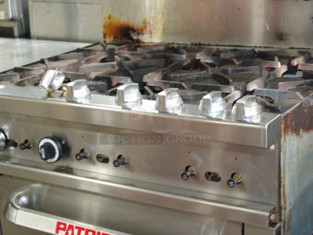 Patriot PT-R36 6-burner natural gas range, 36" wide, heavy-duty with visible wear, control knobs, and "Patriot" label.
