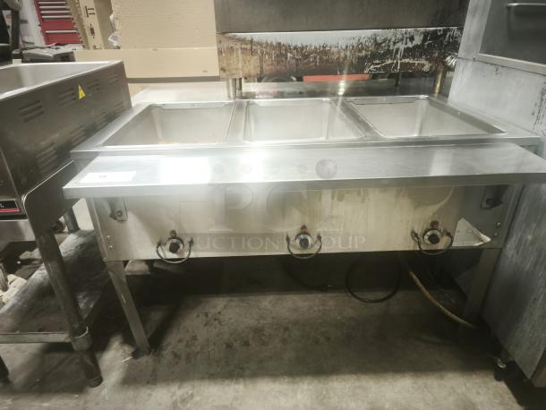 Delfield commercial 3-pan steam table in premium condition, featuring stainless steel design and control knobs for temperature adjustment.