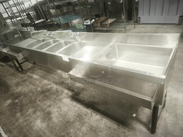 Stainless steel 4-bay bar sink in premium condition. Features two faucets and ample workspace. Ideal for commercial use.