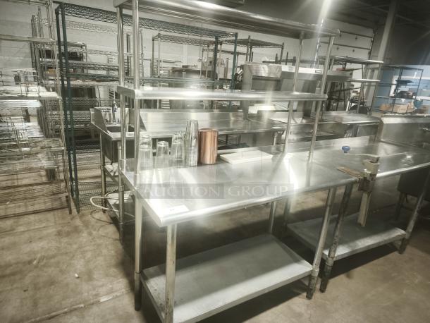 Stainless steel work table with double tier overshelf, excellent condition, ideal for kitchen prep, with visible shelving.