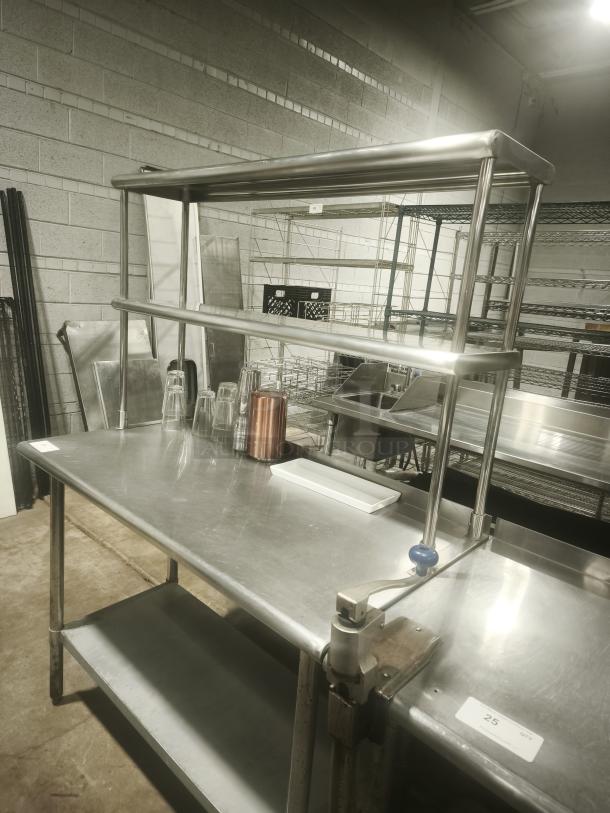 Stainless steel work table in excellent condition with wide double-tier overshelf; ideal for kitchen prep.