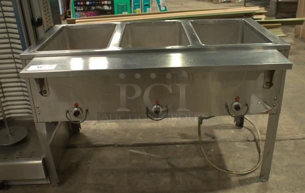 Heavy Duty natural gas hot food table with three wells, stainless steel, used condition, features adjustable controls.
