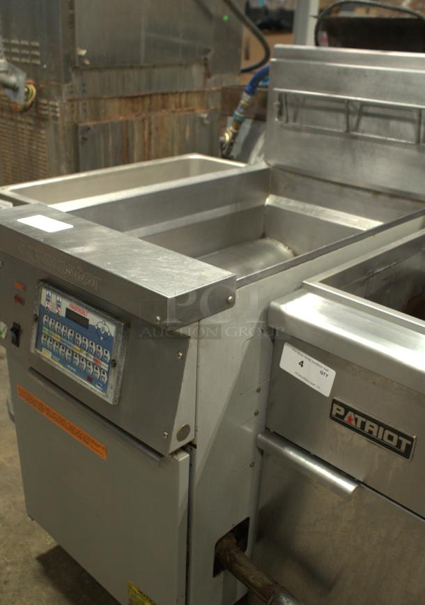 Frymaster commercial deep fryer, heavy-duty stainless steel, used condition, visible control panel and "PATRIOT" label.