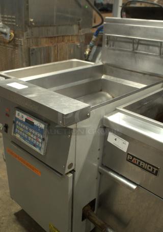 Frymaster commercial deep fryer, heavy-duty stainless steel, used condition, visible control panel and "PATRIOT" label.