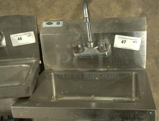 Stainless steel commercial hand washing sink, heavy-duty, NSF-certified, with dual handles. Item tagged "47" for auction.
