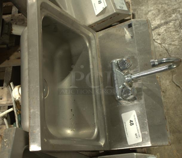 A stainless-steel commercial hand washing sink, heavy-duty, features dual handles and a curved spout. Auction label: "48."