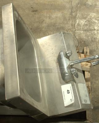 Stainless steel commercial hand washing sink in heavy-duty condition. Features faucet and labeled NSF certification. Ideal for industrial use.