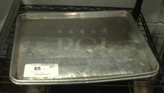 Heavy-duty half-size baking sheet pan, silver, showing signs of wear. Tag indicates auction lot 65, from PCI Auctions.