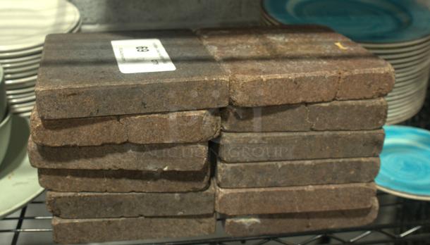 NSF certified volcanic granite slabs for cooking, heavy duty, in good condition, stack of stones on a metal shelf.