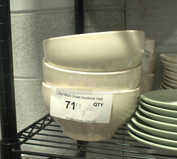 A stack of three white stoneware bowls on a shelf, each featuring a smooth finish. Label indicates auction details.