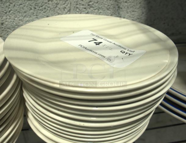 8" vintage-style plates in a stack, cream color, lightly used condition. Auction label indicates quantity of 74.