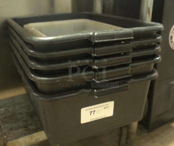 Stack of heavy-duty black plastic bus boxes for commercial use, showing label with quantity and auction info.
