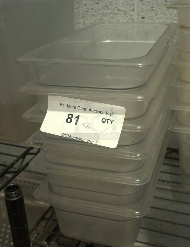 Stack of clear polycarbonate NSF food pans, 1/3 size, 4-inch deep, labeled "81 x6" on the top pan, on metal shelving.