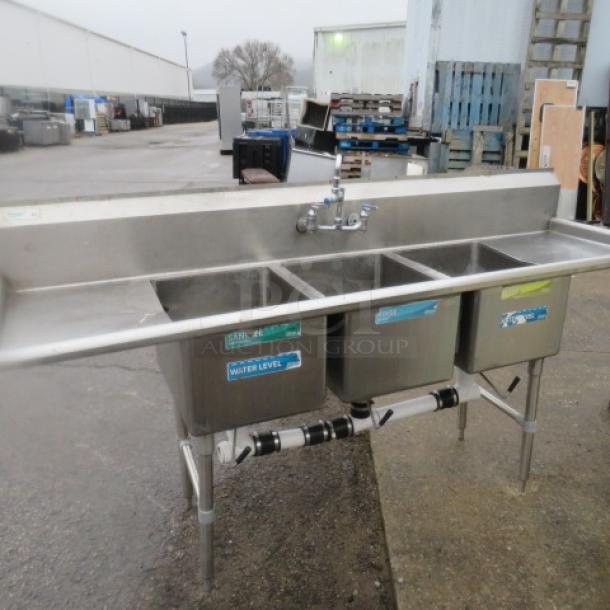 Stainless steel 3 compartment sink with faucet, R/L drain boards, 88x26x45.5 inches, used condition. Tags indicate water level.
