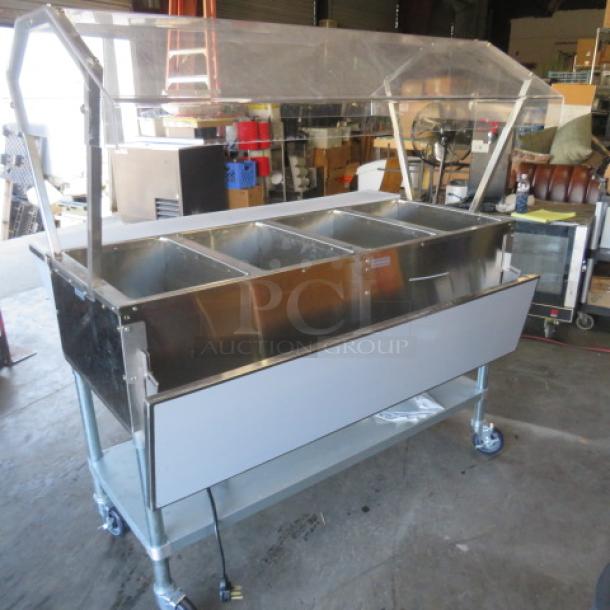 One NEW Servit 4 Well Electric Steam Table, Model 423EST4WO500, with sneeze guards, cutting board, SS under shelf, on casters. 