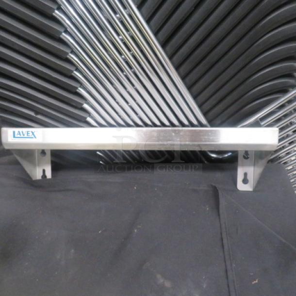 Stainless steel wall mount shelf by Lavex, 18x5 inches, with mounting brackets, in excellent condition.