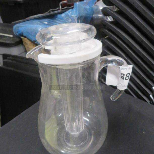 Clear glass pitcher with a handle, white lid, and pull-out core. Good condition. Auction label "388" visible.