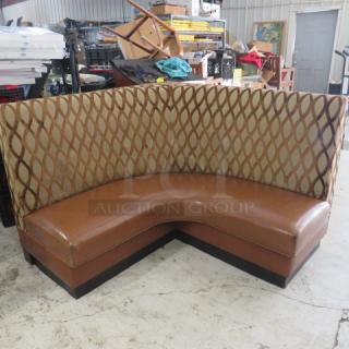 Brown cushioned corner booth, 59x27x42 inches, in good condition. Features a patterned backrest and sturdy frame.