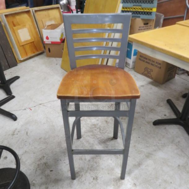Metal bar height chair with wooden seat, gray slatted backrest, sturdy frame, used condition.
