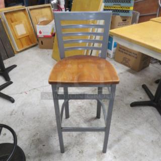 Metal bar height chair with wooden seat, gray slatted backrest, sturdy frame, used condition.