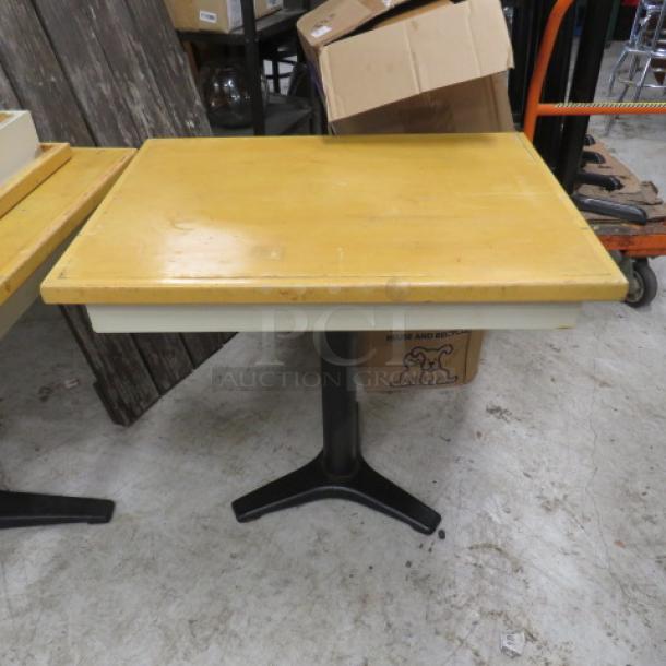 Wooden tabletop on a pedestal base, dimensions 32x32x30 inches. Table shows minor wear; sturdy black pedestal support.