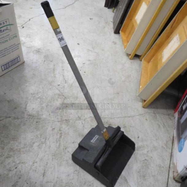 Gray, upright dust pan with attached handle, lightly used. Label displays number "96."