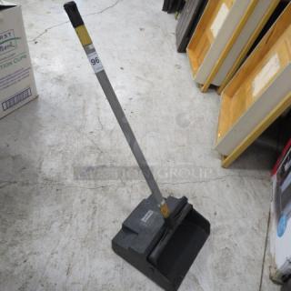 Gray, upright dust pan with attached handle, lightly used. Label displays number "96."