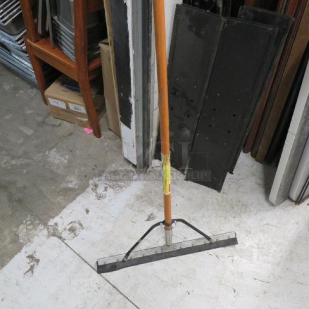 One Squeegee Mop with wooden handle, black rubber blade, and yellow label. Used condition, ideal for floor cleaning.