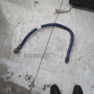Flexible blue gas line with metal connectors; moderate wear, visible white tag reading "26," suitable for industrial use.