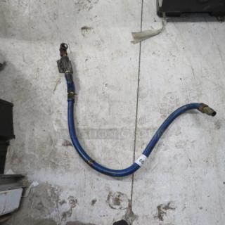 A blue gas line with metal connectors, approximately 3 feet long, shown on a concrete floor. Features a label with the number 60.
