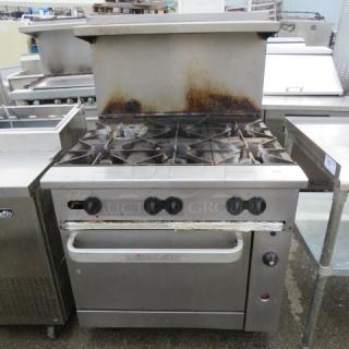 Vulcan 6 burner natural gas range with stainless steel overshelf, 2 racks on casters, 36x34x59 inches, used condition.