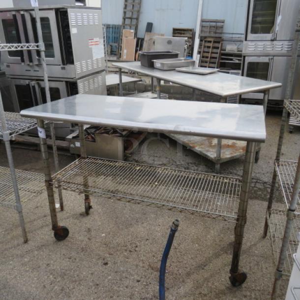 Stainless steel table with Metro under shelf on casters, 49.5x24x37 inches, used condition, ideal for kitchen or workshop use.