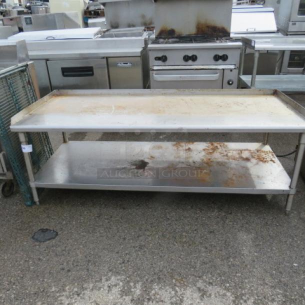 Stainless steel equipment table with under shelf, 73x31x27 inches, showing surface rust and wear.