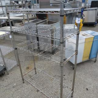 Metal Metro shelf unit with four adjustable wire shelves, size 36x14x54 inches. Slight wear visible, suitable for storage.