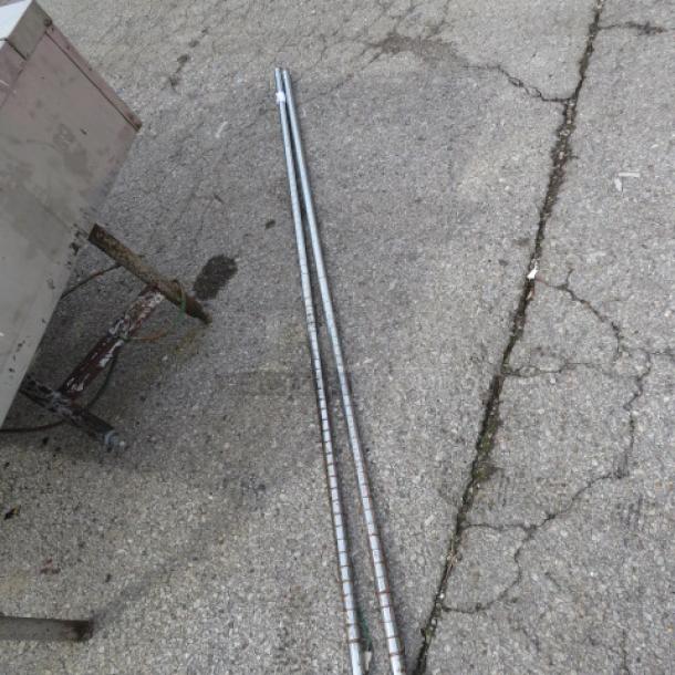 Silver Metro Pole, set of two, used, reflective surface, sturdy construction, suitable for Metro shelving systems.