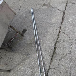 Silver Metro Pole, set of two, used, reflective surface, sturdy construction, suitable for Metro shelving systems.