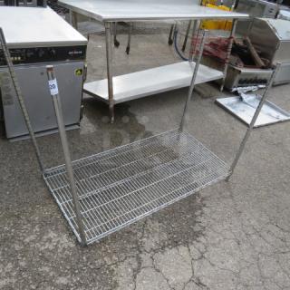 Chrome-finished Metro shelf with four vertical poles, dimensions 48x24x36 inches, in used condition showing slight rust.