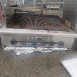 Wells natural gas charbroiler, 36x31x19 inches, used condition, five control knobs, visible wear on grill.