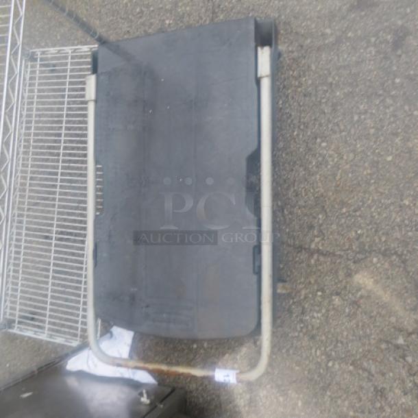 Rubbermaid dolly with metal frame and black platform, used condition, visible wear on the platform.
