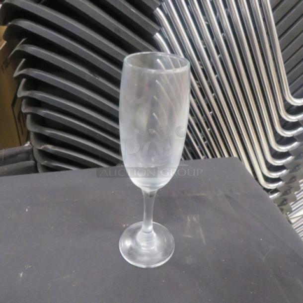 Frosted champagne glass with swirl pattern, standing on a dark surface. Appears in good condition. No visible tags.
