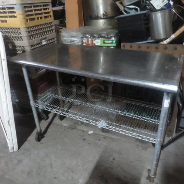 Stainless steel table with Metro under shelf on casters, 49.5x24x36 inches, used condition, ideal for industrial use.